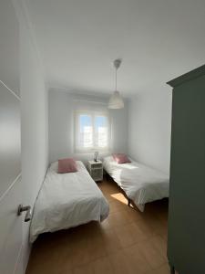 1 dormitorio con 2 camas y ventana en Villa Mariaje, en Cazalla de la Sierra