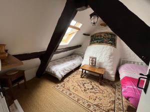 1 dormitorio en el ático con 2 camas y ventana en Idyllic Rural peaceful Cottage, en Gorron