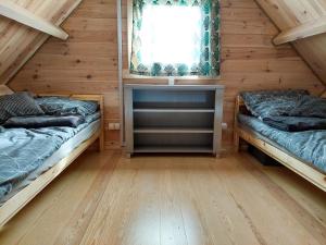 a room with two beds and a window at Cudnie tu - Noclegi na Kaszubach in Wdzydze Kiszewskie