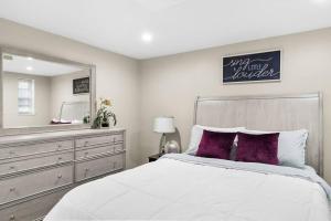 a bedroom with a large bed and a mirror at Elegant 1-BR Apartment in Silver Spring
