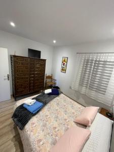 um quarto com uma cama grande e um sofá em Chalet xeitosiño em Astorga
