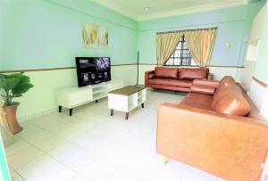 sala de estar con sofá de cuero y TV en 3 Rooms 2 parking 10pax PSR Comfy Sofa&Bed near MRT Eateries McD en Seri Kembangan