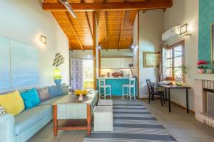 ein Wohnzimmer mit einem blauen Sofa und einer Küche in der Unterkunft Iliachtida House in Kap Sounion