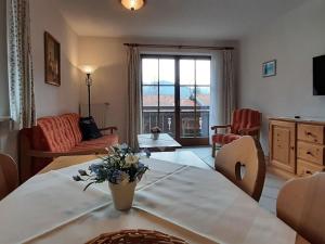 a living room with a couch and a table with flowers at Schönbrunn holiday home in Bayrischzell in Bayrischzell