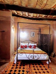 un letto con struttura metallica in una stanza di Kasbah des montagnes maison d'hôtes a Bou Drarar
