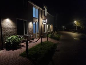 un edificio con un cartel en su costado por la noche en Pension Het Hoefijzer en Buren