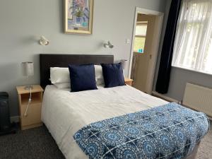 a bedroom with a large bed with blue pillows at Fountain House B&B in Macroom
