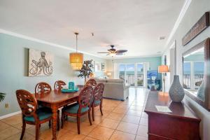 a dining room and living room with a table and chairs at Sea Breeze 106 in St Pete Beach