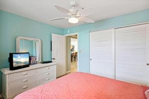 a bedroom with a pink bed and a mirror at Sea Breeze 106 in St Pete Beach