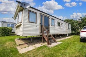 uma pequena casa está estacionada num quintal em 6 Berth Caravan With Free Wifi For Hire In Suffolk Ref 68073bs em Lowestoft
