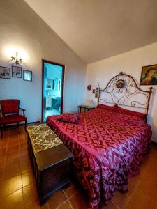 a bedroom with a large bed with a red bedspread at La Casa di Cesarina in Celle sul Rigo