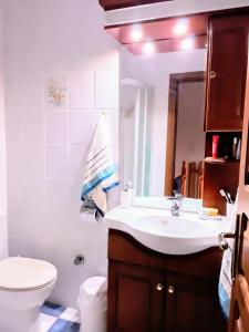 a bathroom with a sink and a toilet and a mirror at La Casa Di Silvia in Apolakkiá +8 photos