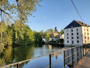Saint-Pryvé-Saint-Mesmin的住宿－Dans moulin au bord de l'eau, Appartement chaleureux，一座河上桥梁上的建筑物