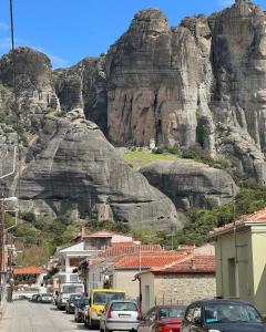 a street with cars parked in front of a mountain at Kalian Meteora in Kalabaka
