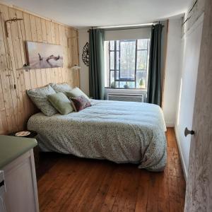 1 dormitorio con cama y ventana en Dans moulin au bord de l'eau, Appartement chaleureux en Saint-Pryvé-Saint-Mesmin