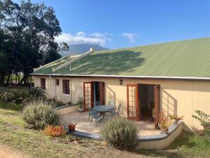 ein kleines weißes Haus mit grünem Dach in der Unterkunft Lakeview Cottage: Rural Retreat in Pampoenkraal