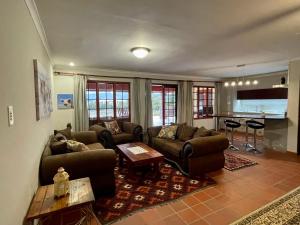 ein Wohnzimmer mit zwei Sofas und einem Tisch in der Unterkunft Lakeview Cottage: Rural Retreat in Pampoenkraal