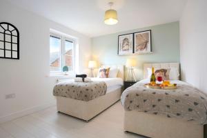 a bedroom with two beds and two windows at Stylish 6 Bedroom 3 Bathroom Detached House with Free Parking, Super-Fast Wifi, Pool Table, Smart TVs with Netflix by Yoko Property in Milton Keynes