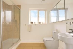a bathroom with a shower and a toilet and a sink at Stylish 6 Bedroom 3 Bathroom Detached House with Free Parking, Super-Fast Wifi, Pool Table, Smart TVs with Netflix by Yoko Property in Milton Keynes