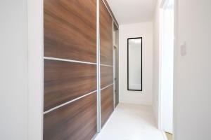 a pivot door in a hallway with wood paneling at Stylish 6 Bedroom 3 Bathroom Detached House with Free Parking, Super-Fast Wifi, Pool Table, Smart TVs with Netflix by Yoko Property in Milton Keynes