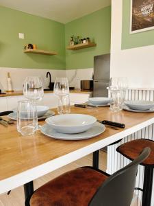 una mesa con copas de vino y platos en ella en Happy House en Torcenay