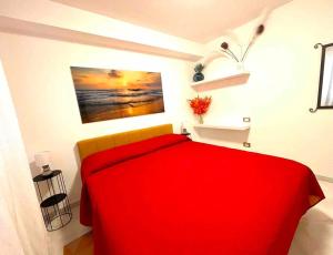 una camera con una coperta rossa su un letto di Casa mare Golfo di Cagliari a Su Forti