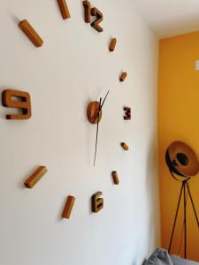 un reloj en una pared blanca con letras. en Happy House, en Torcenay