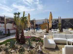 een patio met witte stoelen en tafels op het strand bij Appartamenti Bellavista 107 in Chioggia