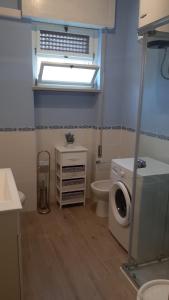 een badkamer met een toilet en een wasmachine bij Villino Lory in Sperlonga