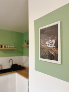 een keuken met groene muren en een foto aan de muur bij Happy House in Torcenay