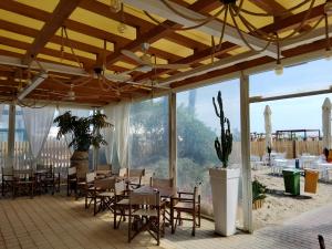 a dining room with tables and chairs and windows at Appartamenti Bellavista 107 in Chioggia