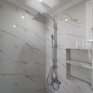 a shower in a bathroom with white marble walls at Venetis Home in Áyios Pétros +32 photos