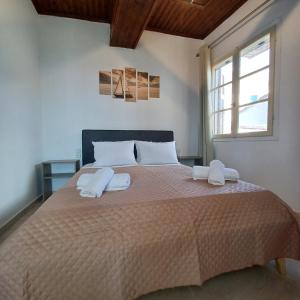 a bedroom with a large bed with two towels on it at Venetis Home in Áyios Pétros