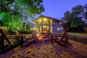 a house with a fire pit in front of it at Benka LifeStyle Country Cottages in Ezulwini