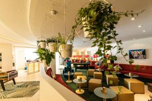 a lobby of a store with tables and plants at Hotel Saalbacher Hof in Saalbach-Hinterglemm