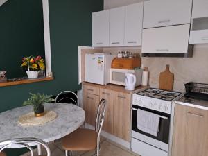 a kitchen with white cabinets and a table with a stove at Twoja Przestrzeń Noclegi Pokoje Mieszkanie Do Wynajęcia in Nowy Sącz