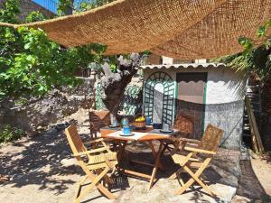 a patio with a table and chairs and a building at Casa di Pilou - Maison et jardin près de la mer - Corbara in Corbara