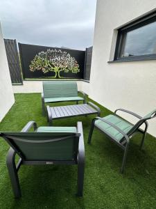 a patio with three chairs and a tree on the wall at La Clé du Bonheur sauna jacuzzi hammam massages 