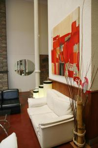 una sala de estar con un sofá blanco y una pintura en Plaza Hotel en Salta