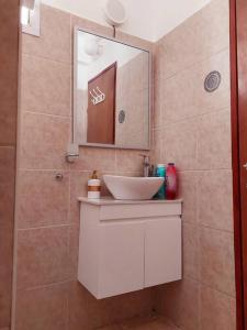 La salle de bains est pourvue d'un lavabo et d'un miroir. dans l'établissement דירת גן בהורקנוס, à Beer-Sheva