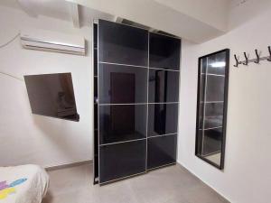- une cabine de douche en verre dans une chambre avec un lit dans l'établissement דירת גן בהורקנוס, à Beer-Sheva