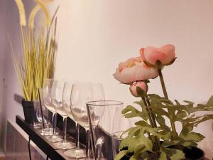 une rangée de verres à vin sur une table avec une fleur dans l'établissement דירת גן בהורקנוס, à Beer-Sheva