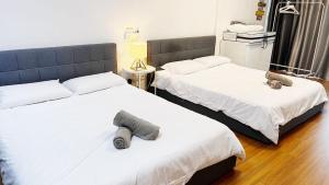 twee bedden naast elkaar in een slaapkamer bij S1 Cozy Home Sunway Geo 2Queens Sunway Medical Centre in Petaling Jaya