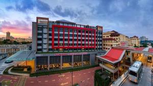 een groot rood gebouw in een stad met een bus bij S1 Cozy Home Sunway Geo 2Queens Sunway Medical Centre in Petaling Jaya