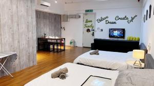 een kamer met 2 bedden en een tv aan de muur bij S1 Cozy Home Sunway Geo 2Queens Sunway Medical Centre in Petaling Jaya