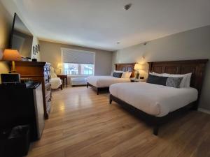 een slaapkamer met 2 bedden en een woonkamer bij The Stowe Village Inn in Stowe