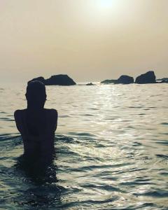 a person sitting in the water in the ocean at Villa El Buzo in Zahara de los Atunes