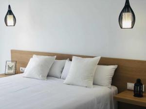 a bedroom with a white bed with white pillows at Villa El Buzo in Zahara de los Atunes
