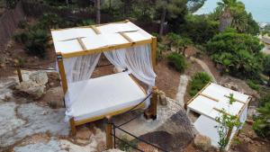 a bed sitting on top of a hill with the ocean at Villa El Buzo in Zahara de los Atunes