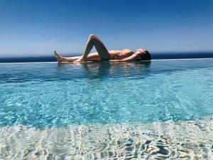 a woman laying on her back in the water at Villa El Buzo in Zahara de los Atunes